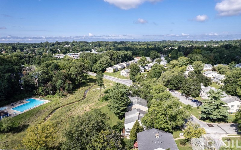 A bird's eye view of a residential area with houses and a swimming pool.