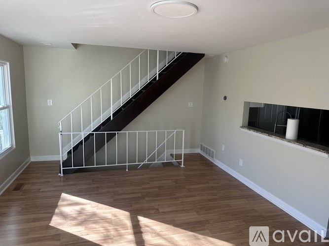 A wooden floor with a metal railing staircase.