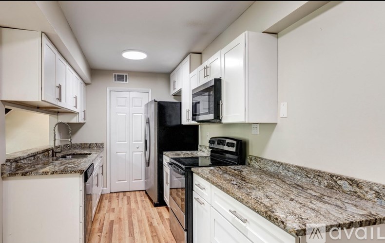 A kitchen with granite countertops and white cabinets.
