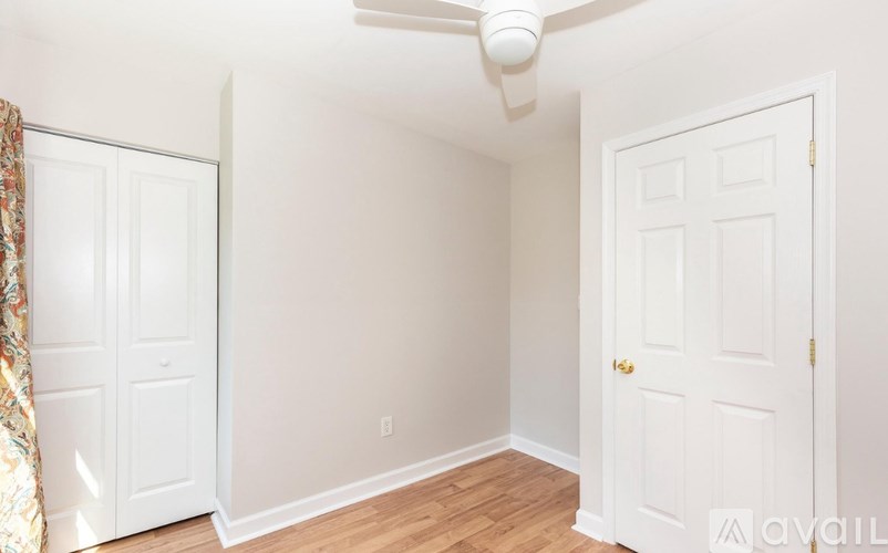 A room with a ceiling fan and two doors.