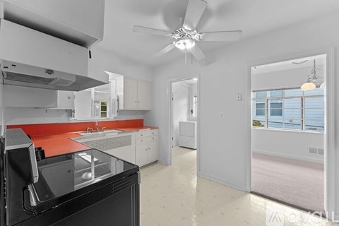 A modern kitchen with a black oven and a red backsplash.