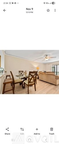 A living room with a couch, chairs, and a dining table.