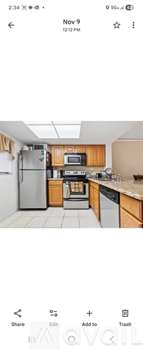 A kitchen with wooden cabinets and a stainless steel refrigerator.