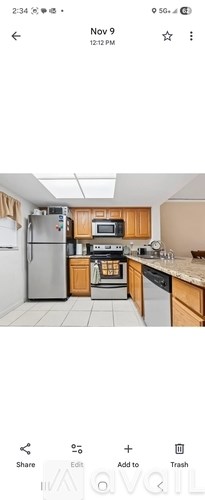 A kitchen with wooden cabinets and a stainless steel refrigerator.