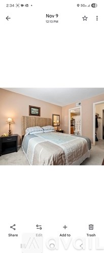 A bedroom with a bed, nightstand, and lamp.