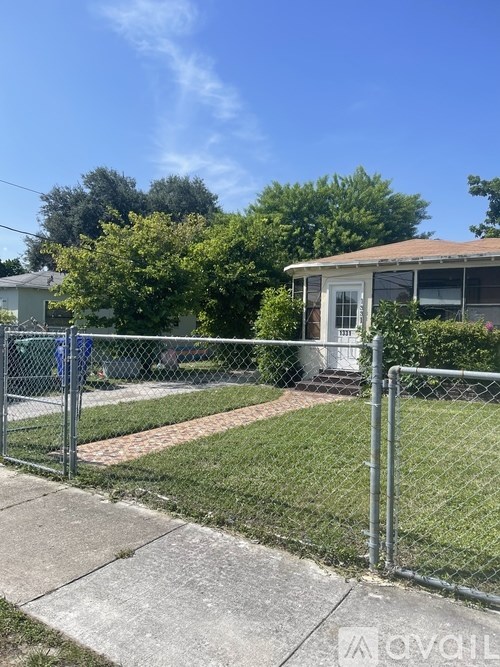 A house is behind a chain link fence.