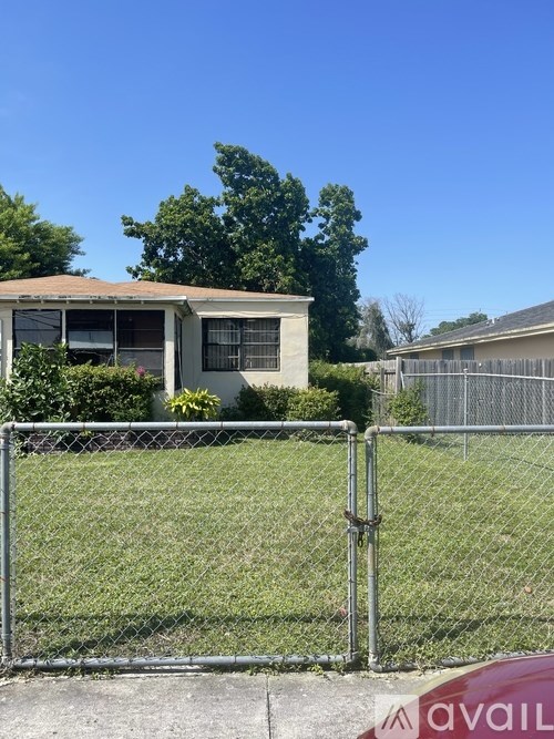 A house with a chain-link fence in front of it.