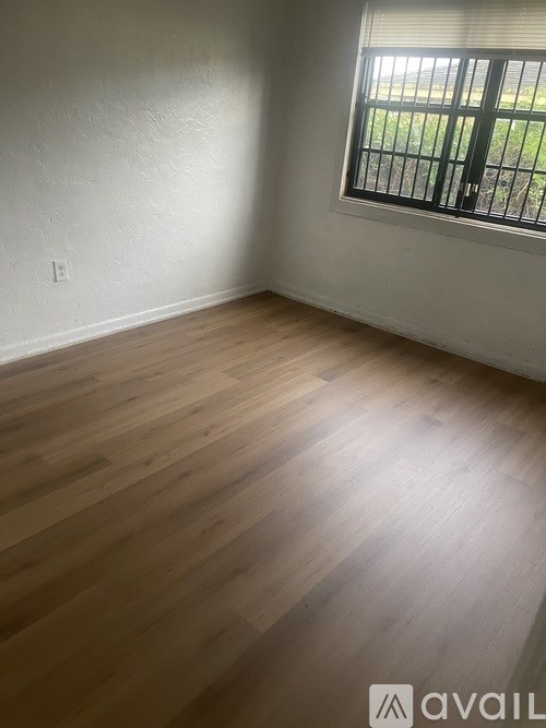 A room with a ceiling fan and two windows.