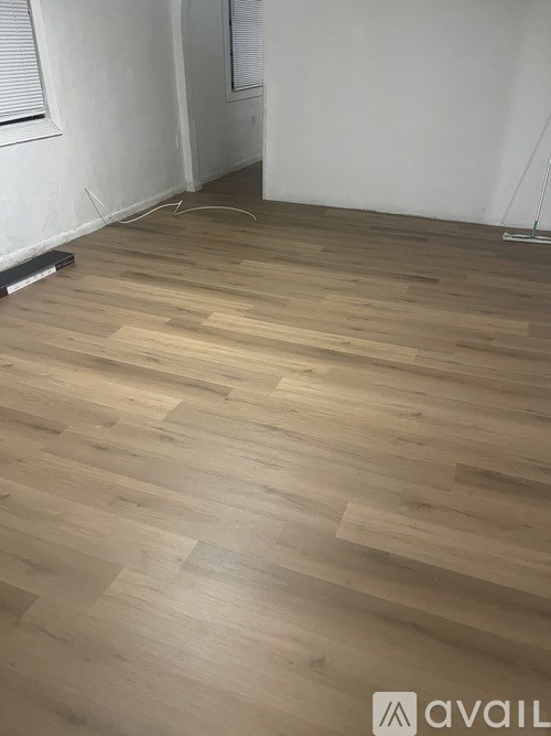 A room with wooden flooring and a white wall.