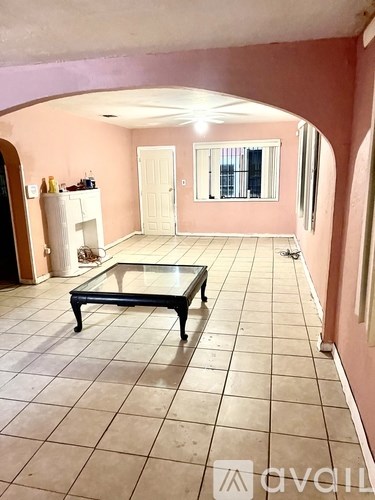 A living room with a glass table and a white cabinet.