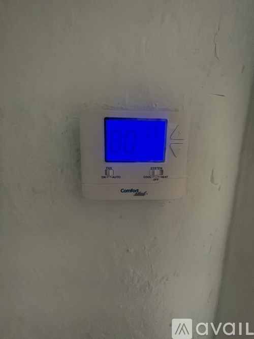 A room with a ceiling fan and a window with blinds.