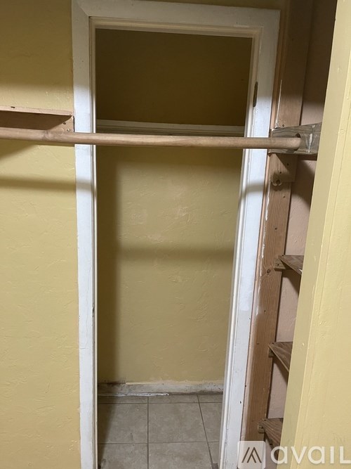 A white door is open to a room with yellow walls.