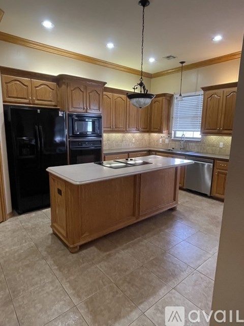 A kitchen with wooden cabinets and black appliances.