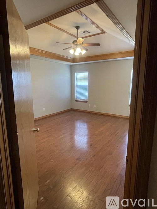 A room with wooden floors and a ceiling fan.