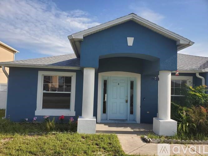 A blue house with a white door and windows.