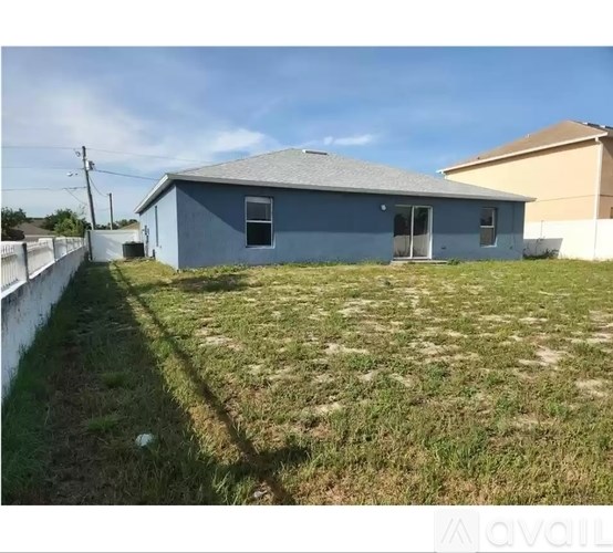 A blue house with a white fence in front of it.