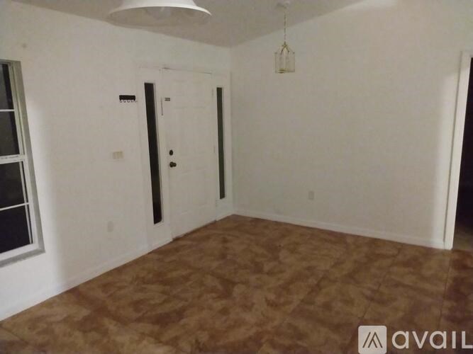 A room with a brown floor and a white door.