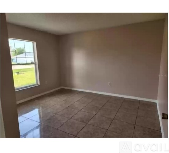 Empty room with tiled floor and a window.