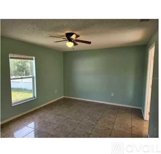 A room with a ceiling fan and a window.