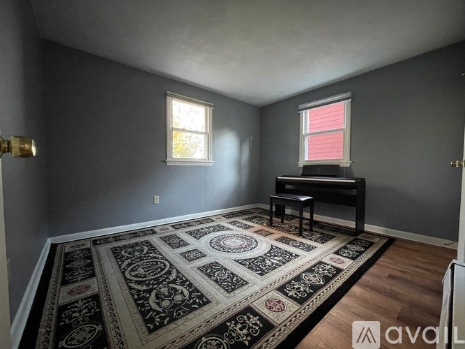 A room with a rug and a piano.