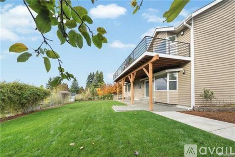 A house with a balcony and a green lawn in front.