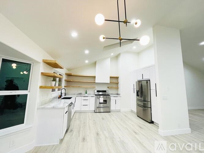 A modern kitchen with white cabinets and stainless steel appliances.