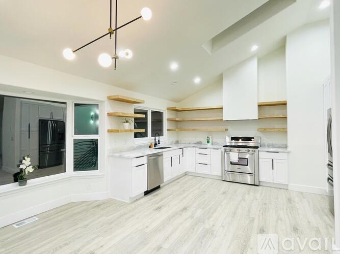 A modern kitchen with white cabinets and stainless steel appliances.