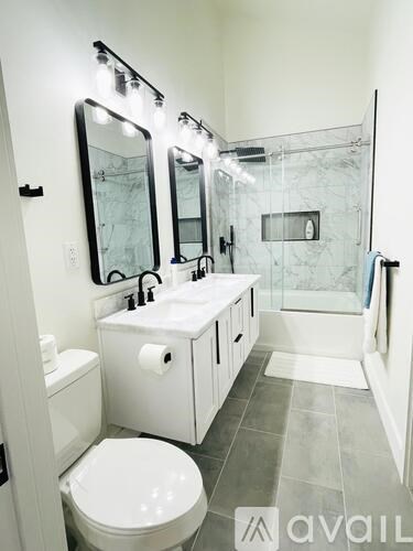 A bathroom with a toilet, sink, and mirror.