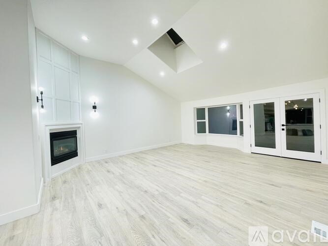 A spacious room with a fireplace and a skylight.