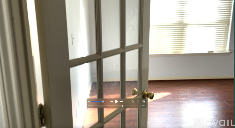 A white door with a gold handle and a window with blinds in the background.