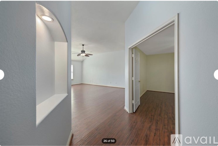 A room with a ceiling fan and wooden floors.