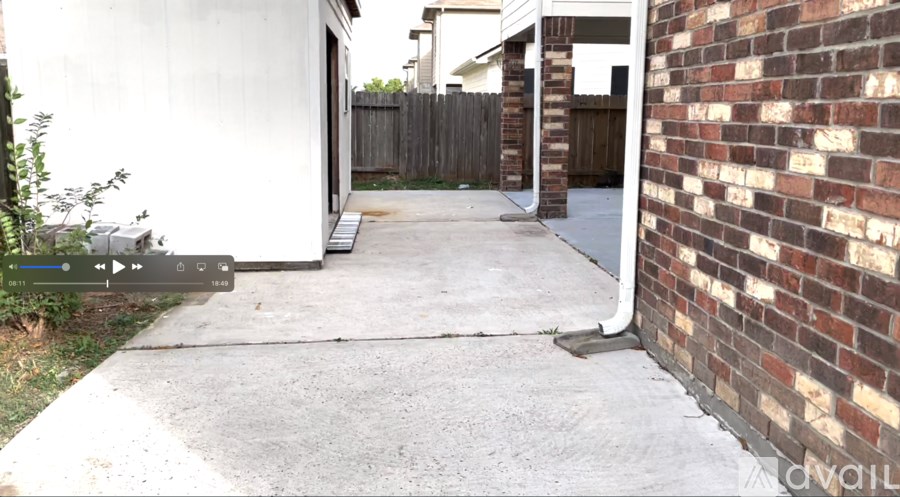 A white house with a brick wall on the right side.