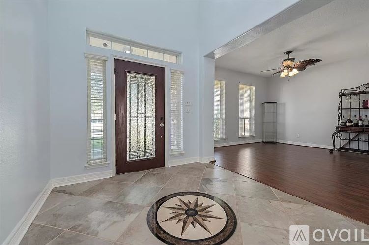 A room with a rug on the floor and a ceiling fan.