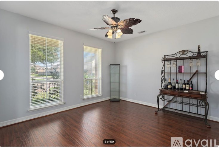 A room with a ceiling fan and a wine rack.