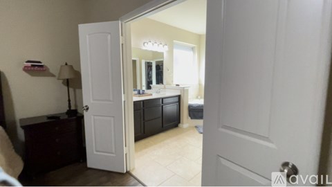 A room with a white door is visible, and a lamp is on a table.