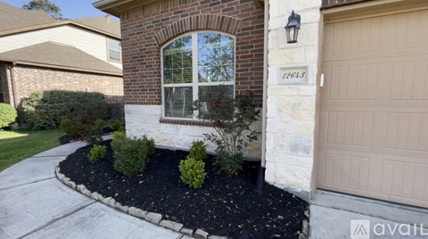 A house with a brick arch window and a garage door.