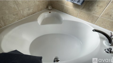 A white bathtub with a black towel and silver faucet.