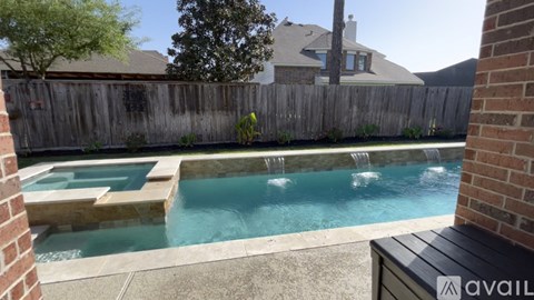 A pool with a waterfall feature in the middle of it.