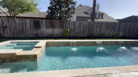 A pool with a waterfall feature in the middle of it.