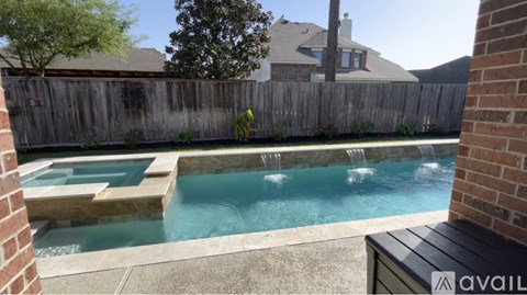 A backyard with a pool and a wooden fence.