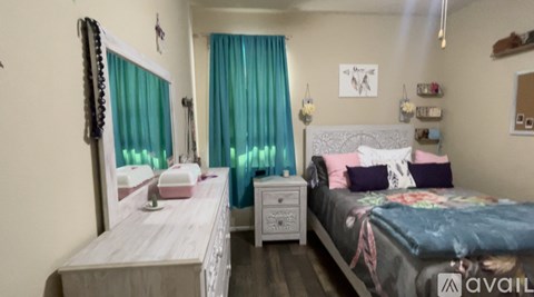 A bedroom with a bed, nightstand, and dresser.