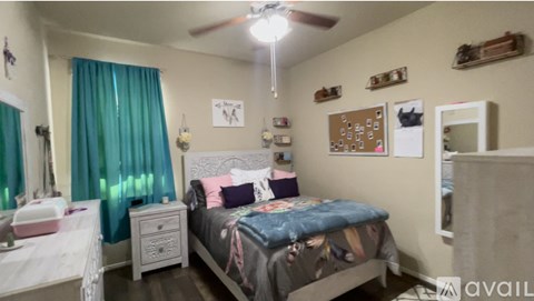 A bedroom with a bed, nightstand, and a ceiling fan.