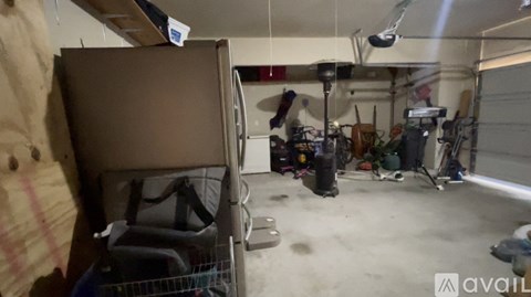 A garage with a brown refrigerator and various tools.