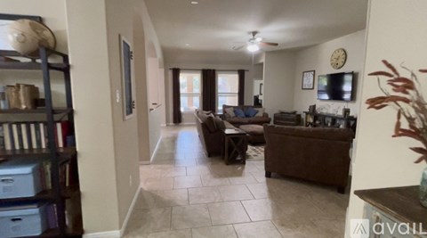 A living room with a couch, a chair, and a television.