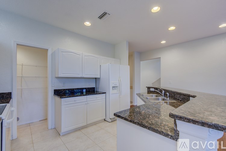A kitchen with granite countertops and white cabinets.