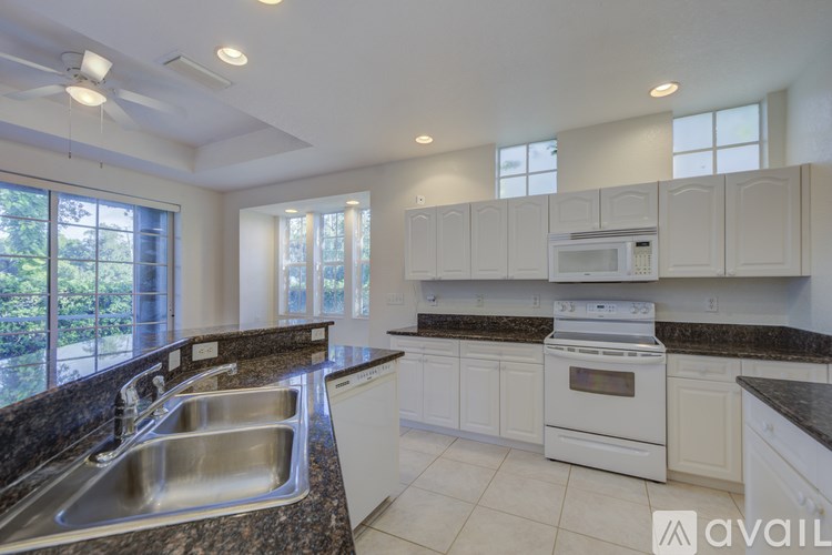 A kitchen with white cabinets and a granite countertop.