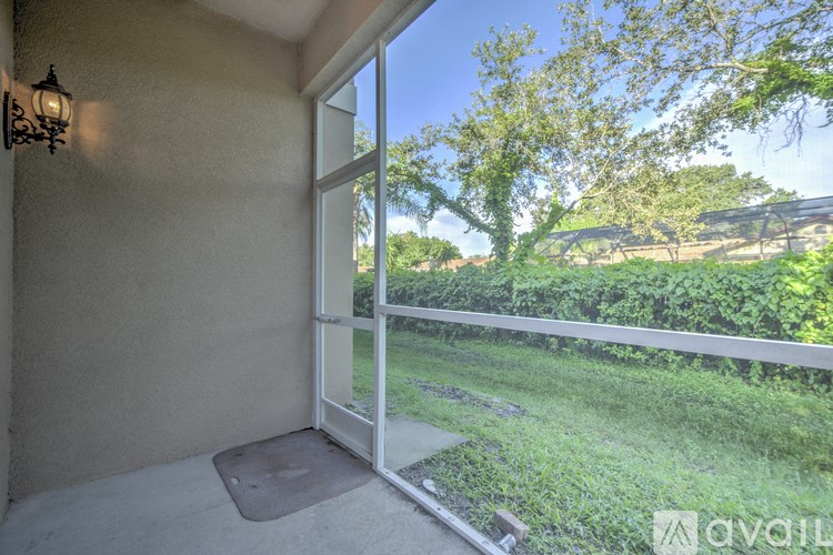 A patio with a sliding glass door leading to a green backyard.