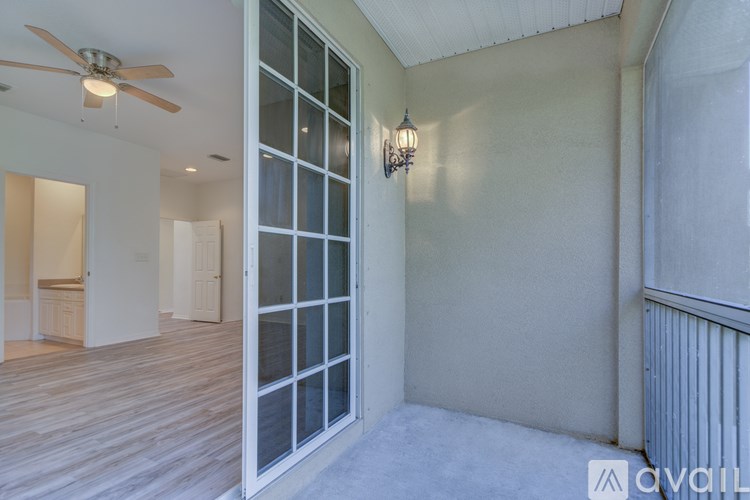 A room with a ceiling fan and a wall-mounted light fixture.