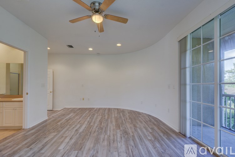 A room with a ceiling fan and wooden flooring.