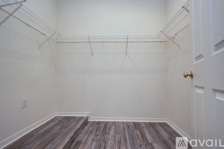 A room with a white door and a wall with a shelf.